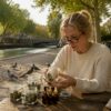 Assise à sa table de cuisine, une femme se renseigne sur les produits à base de CBD.