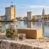CBD La Rochelle : le guide essentiel pour votre achat 3 CBD La Rochelle : fleurs de chanvre, résine et colis devant une évocation des tours du Vieux-Port.